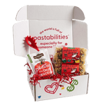 Front view of two 14 oz Naughty or Nice pasta bags showing red label and mixed holiday-shaped pasta on white background