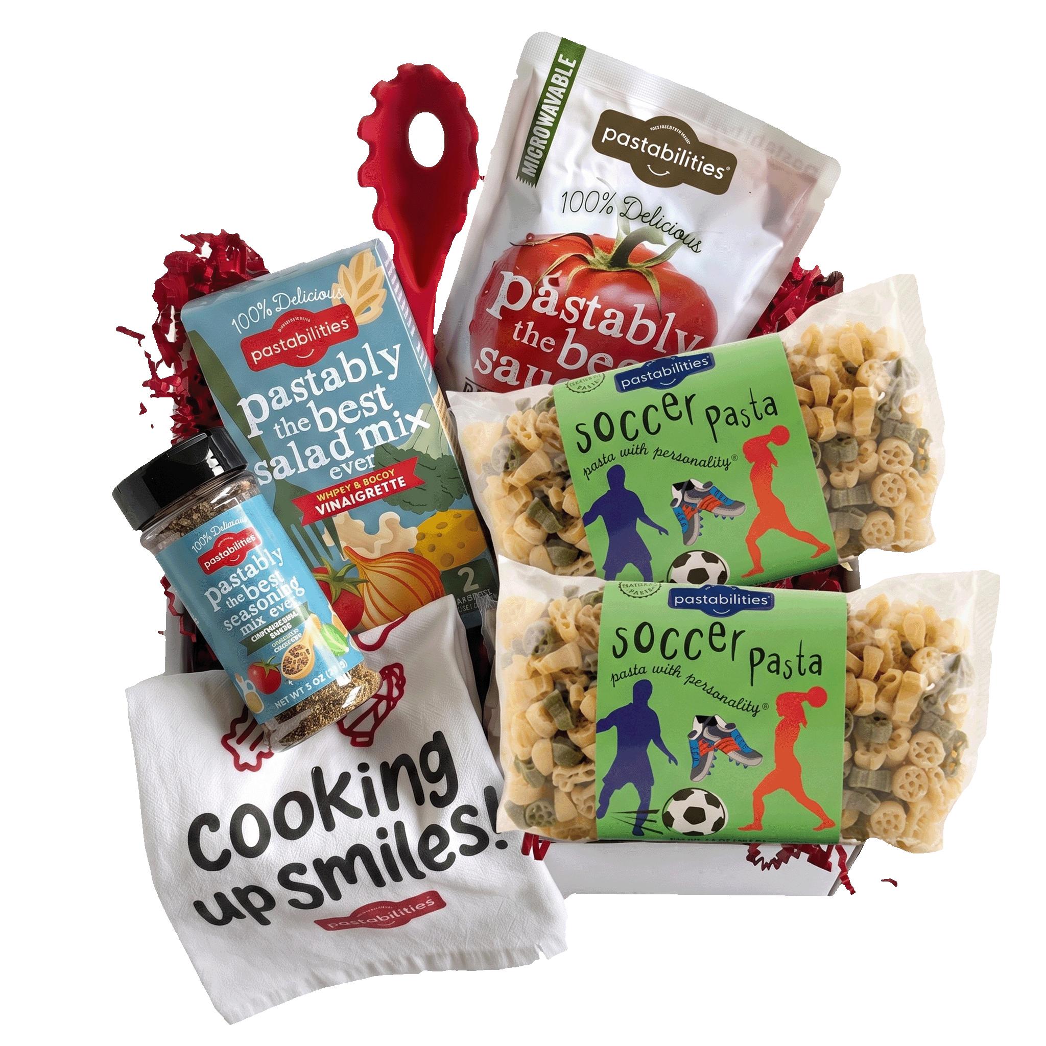 Front view of Soccer Pasta deluxe box showing two 14 oz bags of soccer-shaped pasta with sauce, fork, vinaigrette, seasoning, and towel on white background