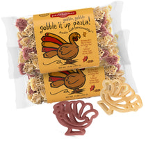 Front view of Gobble Gobble turkey-shaped pasta two-pack showing two 14 oz bags and red and yellow turkey-shaped noodles on white background