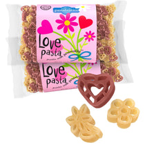 Front view of Love Pasta two-pack showing pink floral label and red and yellow heart- and flower-shaped pasta on white background